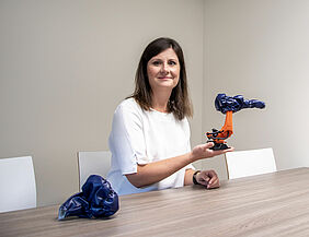 Claudia Ebert zeigt einen kleinen Roboter