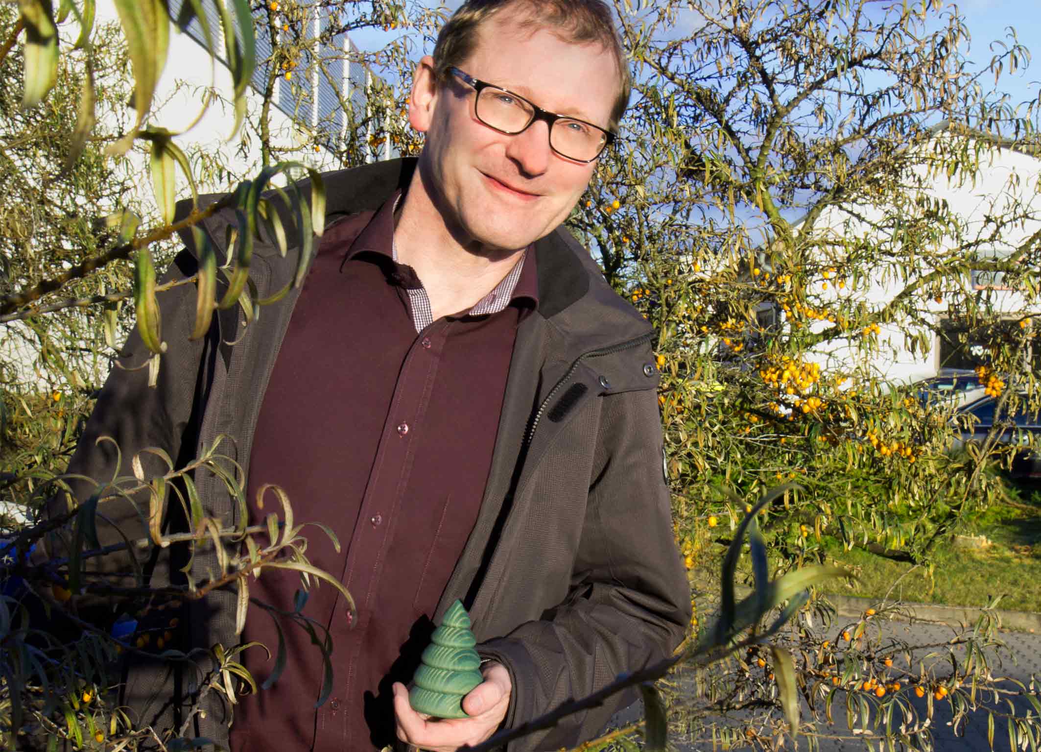 Thomas Kimme hält einen gedrechselten Tannenbaum in der Hand.